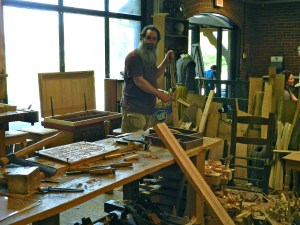 Peter splitting wood with a froe and answering questions from the audience