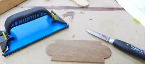 Clean up the curves with the Sloyd knife, then break the edges with the sanding block.