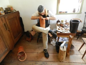 The shoemaker plying his craft -- in this case making a leather bucket.