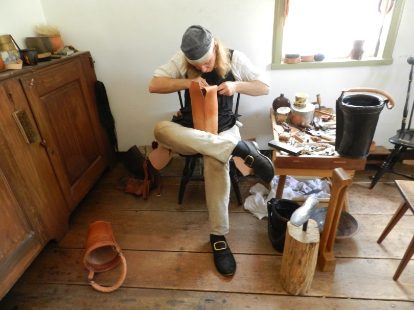 The shoemaker plying his craft -- in this case making a leather bucket.