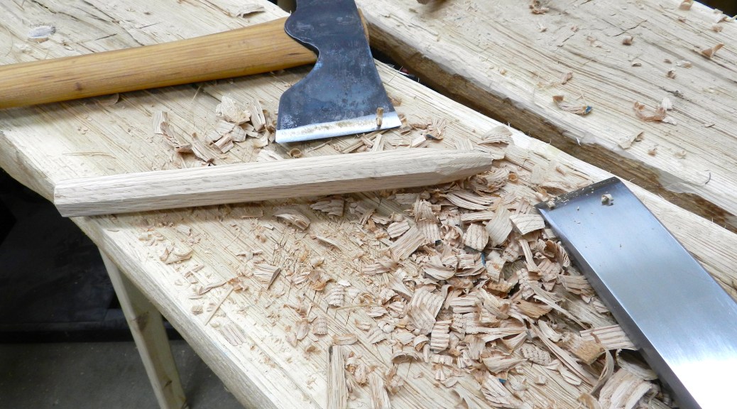 Using the hewing bench, carpenter's axe and timber framing chisel to taper the ends of each pin