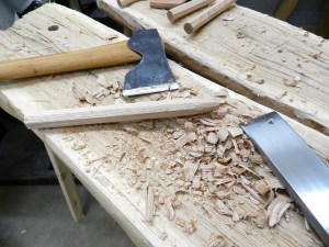 Using the hewing bench, carpenter's axe and timber framing chisel to taper the ends of each pin