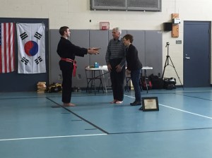 Lee presenting his black belt to his parents